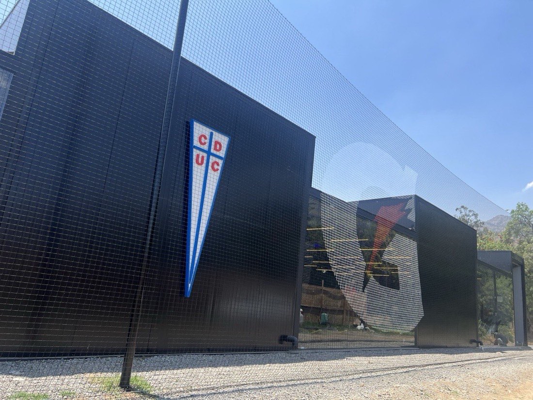 Malla perimetral con escudo de Universidad Católica en San Carlos de Apoquindo